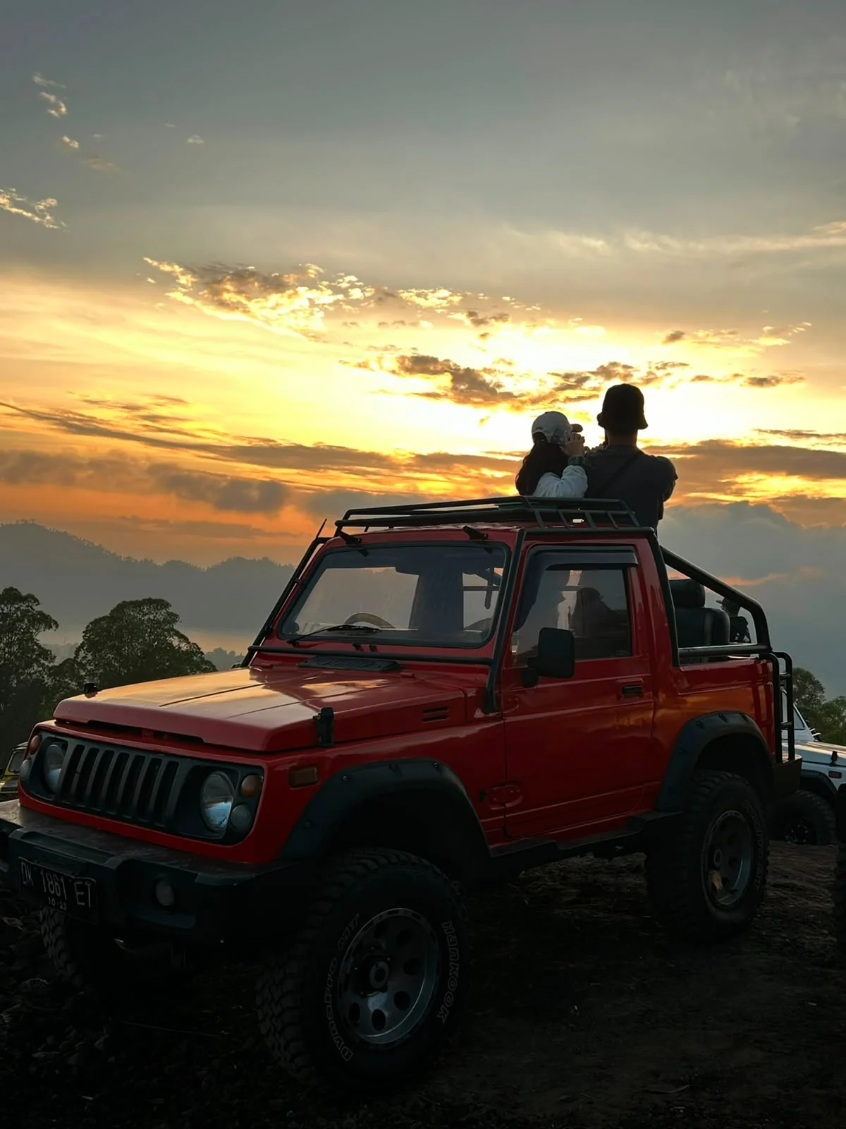 Red jeep during sunrise near Mount Batur